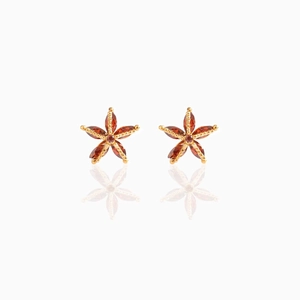 Detailed view of gold star stud earrings with five marquise-cut dark red gemstones