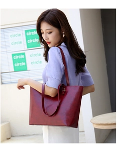 Deep red leather tote bag showing large capacity and side profile on shoulder
