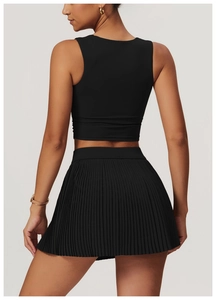 Rear view of black pleated tennis skirt and racerback crop top for gym and sports