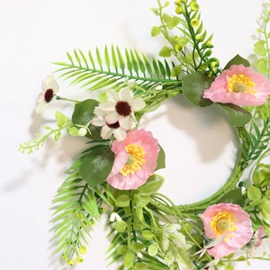 Close-up of pink and white daisy wreath with green foliage for wedding table decor