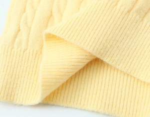 Macro shot of yellow ribbed knit texture and soft wool fabric details on the sweater