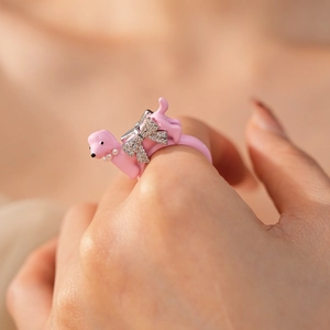 Pink dachshund ring with diamond bow and pearl collar details on model's finger