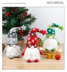 Close-up of three festive Christmas gnomes in grey, red and green on a wooden table