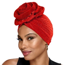 Détail d'un turban rouge pailleté pour femme avec un grand motif de rose en 3D