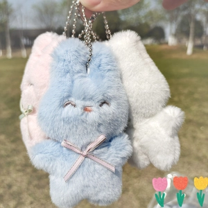 Trois porte-clés lapin en peluche bleu, rose et blanc avec chaînes à billes en plein air