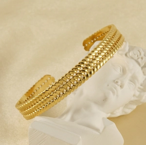 Vue détaillée de la texture tressée dorée sur un bracelet jonc réglable en acier inoxydable