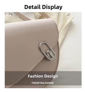 Detailed close-up of a silver oval metal twist lock on a pink leather saddle bag