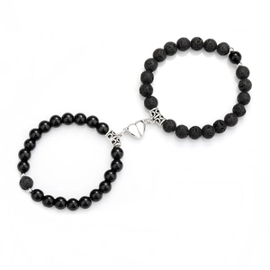 Detail of magnetic heart clasp connecting matte black and polished beaded bracelets