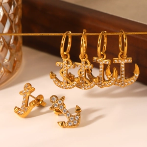 Detailed view of 18K gold plated anchor earrings with sparkling white crystals set