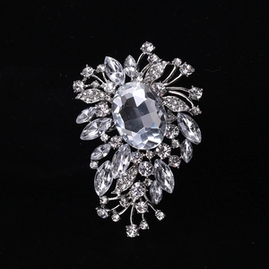 Macro shot of silver alloy brooch with crystal rhinestones on black velvet background