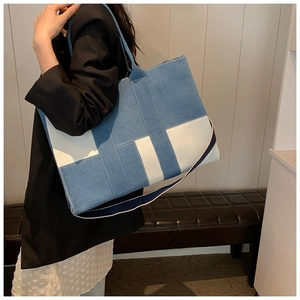 Lifestyle view of a large patchwork denim tote bag with H-pattern and wide strap