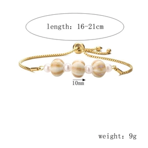 Dettaglio di un bracciale dorato regolabile con perle marmorizzate e piccole perle bianche