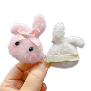 Cute plush rabbit hair clips for girls featuring pink ribbon bows and soft fabric texture