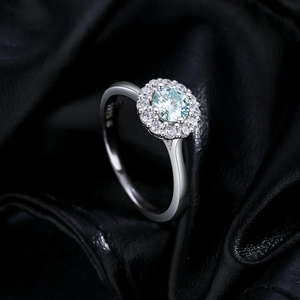 Elegant S925 silver ring featuring a blue moissanite center stone on black fabric background