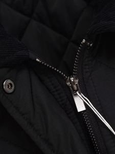 Detail einer schwarzen Steppjacke mit Cordkragen und glänzendem Metallreißverschluss