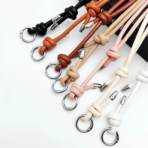 Detail of adjustable leather bag straps with knot design and silver spring clasps