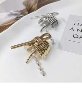 Detailed macro view of gold and silver ponytail hair hooks with elegant pearl tassels
