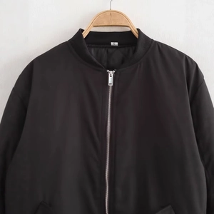 Veste bomber oversize noire minimaliste avec fermeture éclair argentée et manches plissées