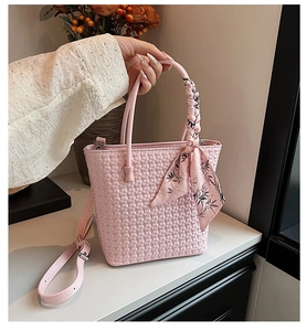 Pink woven bucket bag detailed with decorative leaf print silk scarf on the handle