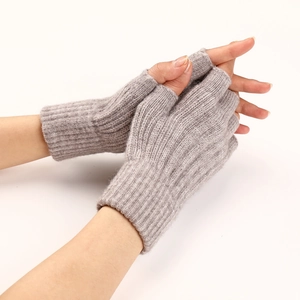 Close-up of grey cable knit fingerless gloves showing texture and elastic cuffs