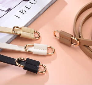 Detail view of thin PU leather belts in four colors with elegant gold oval buckles