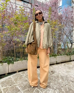 Détails d'un blouson aviateur olive avec pantalon large et grand sac clouté en daim