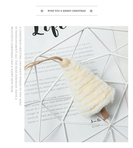 Close-up of bohemian style macrame Christmas tree ornament with cream fringe and wood bead