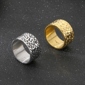 Detailed close-up of gold and silver stainless steel rings with Celtic braided texture