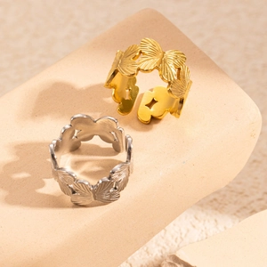 Polished titanium steel butterfly open rings in gold and silver on stone base