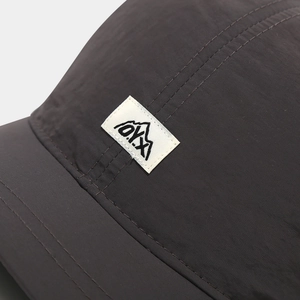 Macro shot of waterproof nylon fabric and DYX logo patch on baseball cap