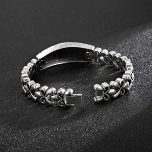 Détails macro d'un bracelet en acier argenté vintage avec gravures de fleurs et fermoir