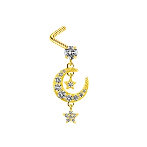 Détail d'un piercing de nez en L doré orné de pendentifs lune et étoiles sertis de strass