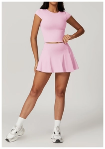 Gonna da tennis a pieghe rosa a vita alta con crop top coordinato indossato da modella