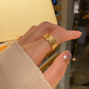 Close-up of golden feather texture on adjustable stainless steel ring with natural veins