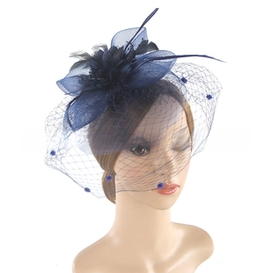 Detail of navy blue fascinator with polka dot mesh veil, ribbon bow, and black feathers