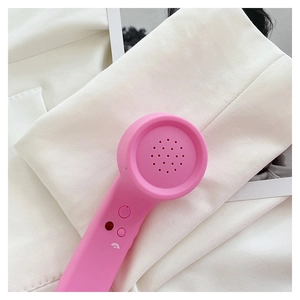 Detailed macro shot of a retro pink telephone handset bag accessory with matte texture