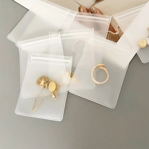 Frosted EVA jewelry pouches in various sizes with golden accessories on grey background