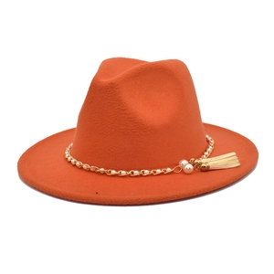 Detail eines orangefarbenen Wollhutes mit Goldkette, Perlen und beigefarbener Quaste