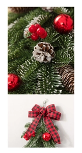 Close-up of frosted Christmas wreath featuring red berries and plaid bow on wall