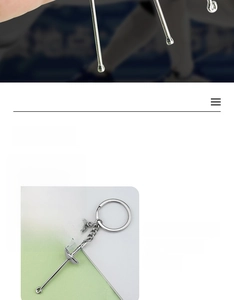 Detailed close-up of a silver fencing mask and sword charms on a metal keychain