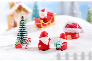 Close-up of resin Christmas miniatures set with Santa Claus, mini tree, and a snow cottage