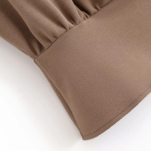 Detailed macro view of brown crinkled crepe fabric texture with fine pleated sewing craft