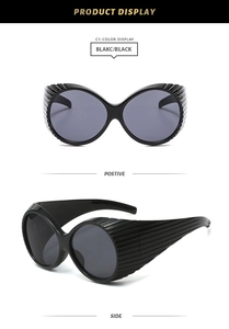 Detail of Y2K wraparound sunglasses with vertical stripe texture on black temples