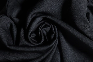 Macro shot of high-quality black knitted fabric texture with elegant soft folds and shadows