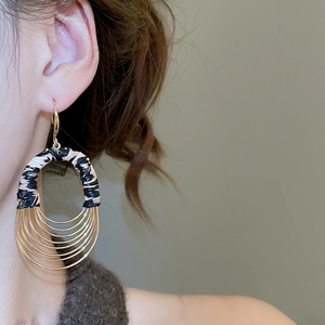 Detail of bohemian layered gold hoops and striped fabric wrap on vintage earrings