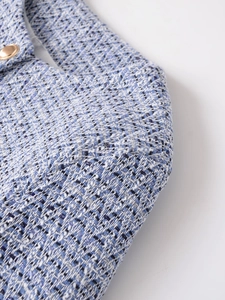 Macro shot of tweed jacket fabric showing blue weaving and gold metal buttons
