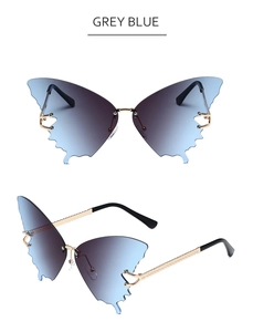 Close-up of grey blue gradient lenses and gold wavy metal temples on butterfly sunglasses