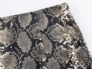Detail of snake print midi skirt showing seamless side invisible zipper and fabric texture