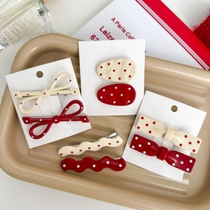 Detailed close-up of red and beige polka dot hair clips set on a display tray