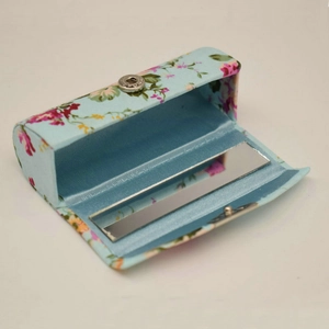 Detail of light blue floral silk lipstick box with interior mirror and embroidery